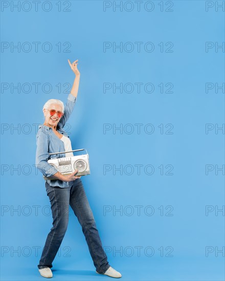 Modern senior woman with vintage radio