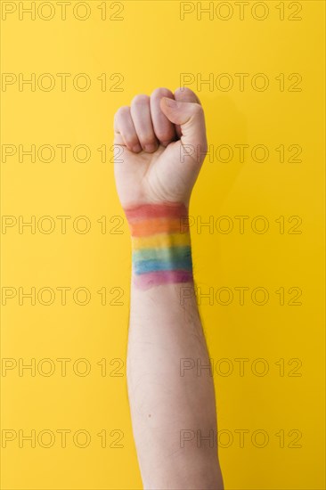 Person holding fist with rainbow flag wrist
