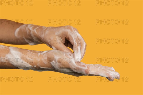 Person washing hands isolated orange