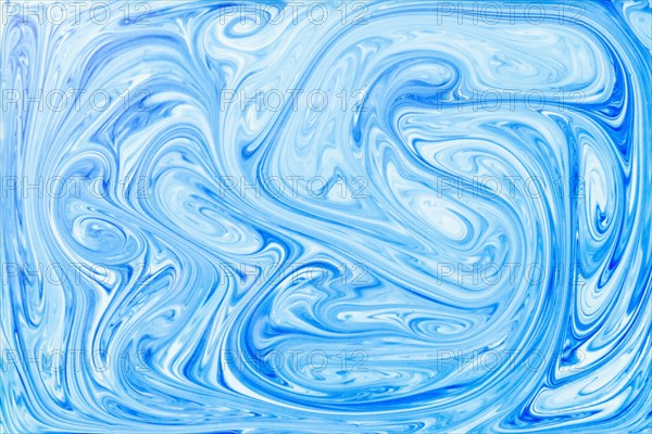 Style ebru painting with blue acrylic paint swirls