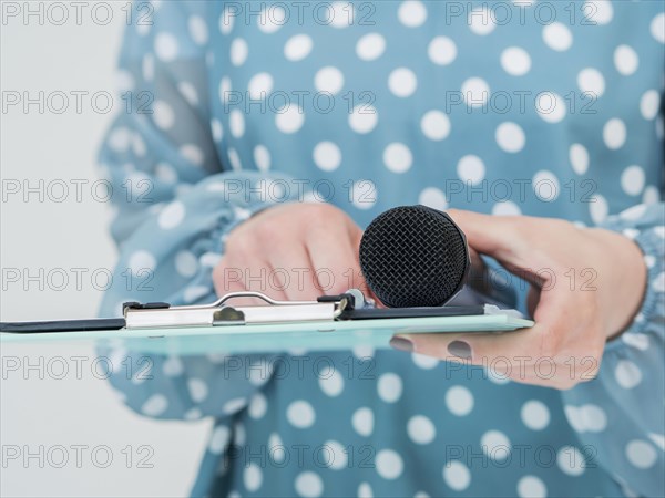 Woman holding microphone clipboard