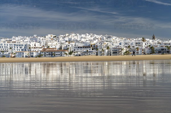 The town view of Conil reflected on the beach Playa De Los Bateles