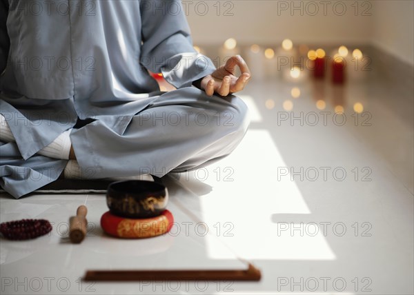 Front view woman meditating with incense candles