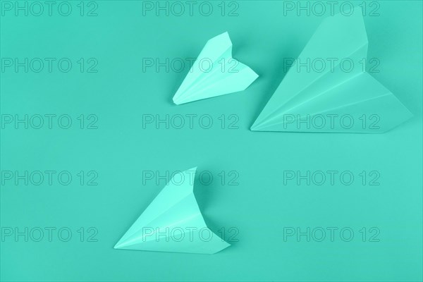 Overhead view green paper airplanes mint background