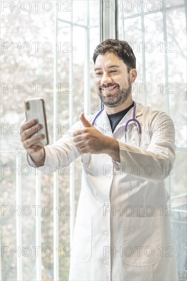 Latino doctor having video conference with his phone