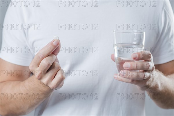 Close up man s hand holding white pill glass water hand