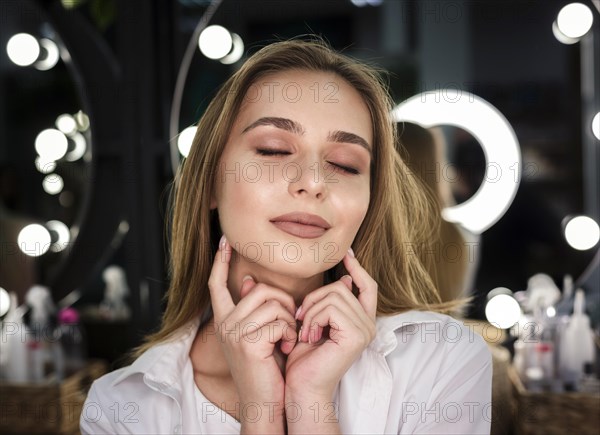 Woman touching face with eyes closed