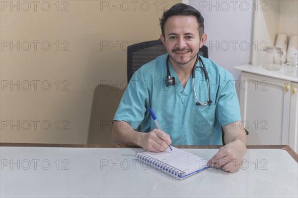 Latin doctor sitting at his desk taking notes