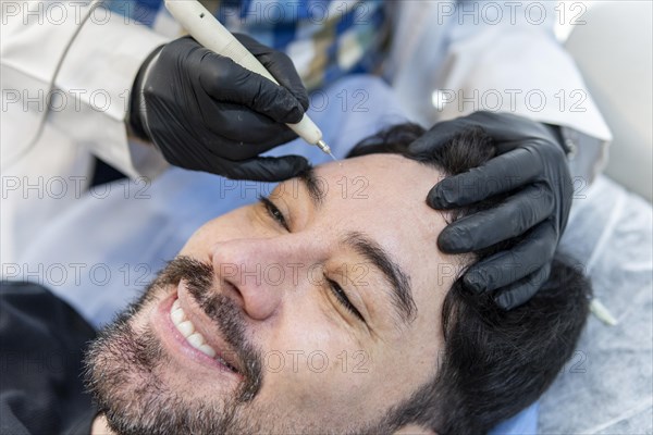 Latino man getting cosmetic treatment on his face