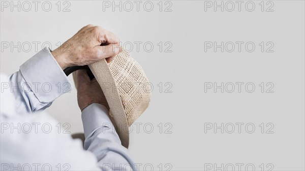 Old man holding hat cane