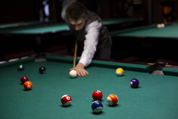 Medium shot guy with pool cue playing billiard