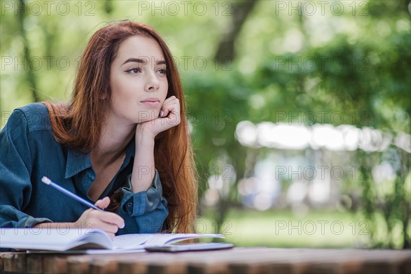 Girl lying table park writing