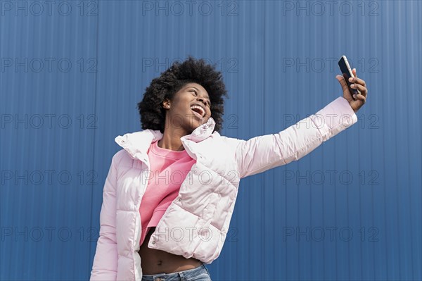 Portrait young woman with mobile jumping