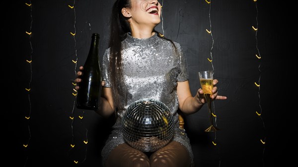 Smiling lady with disco ball bottle glass