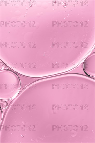 Translucent oil drops water soft pink blurred background