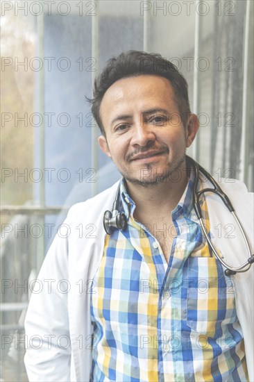 Portrait of latin doctor posing in his office
