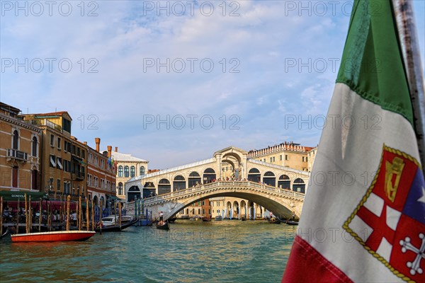 Beautiful view of Italian maritime flag and bridge of Rialto or ponte Rialto on Grand Canal on Venice