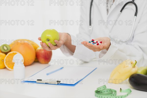 Doctor with pills fresh fruits