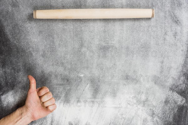 Flour background with rolling pin hands making ok sign