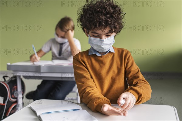 Front view child with medical mask disinfecting hands class