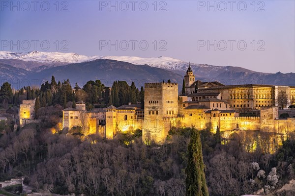 View from the Mirador de San Nicolas of Alhambra and the snow-capped mountains of the Sierra Nevada at dusk