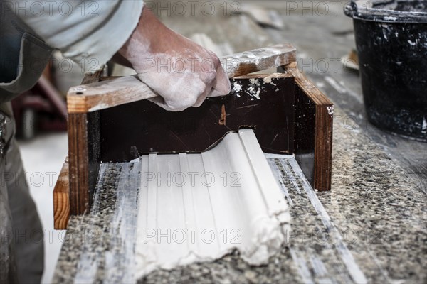 A plasterer creates a stucco profile