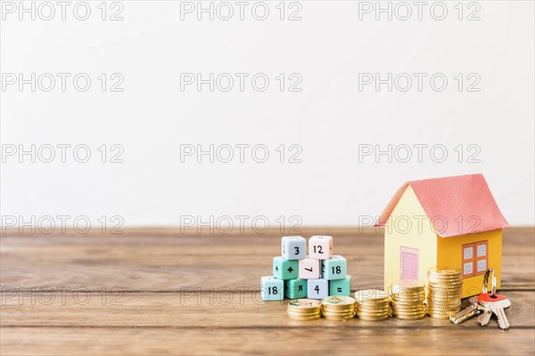 Math blocks house key stacked coins wooden surface