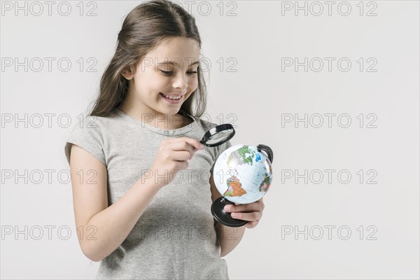 Junior girl studying globe loupe