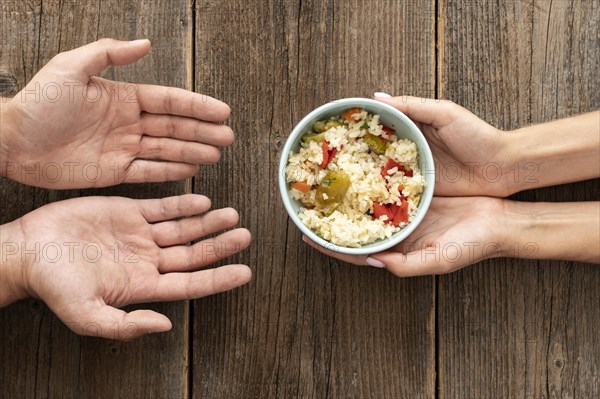 Hand giving bowl food needy person