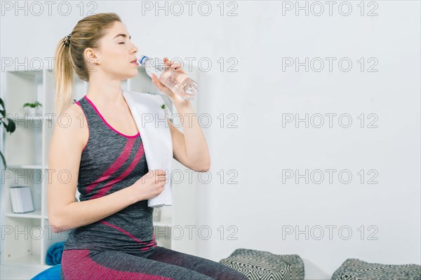 Fitness young woman sportswear drinking water from bottle
