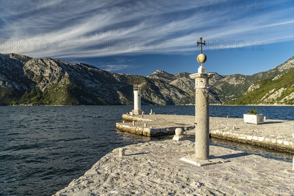 Cross and lighthouse on the artificial island of Gospa od Skrpjela near Perast on the Bay of Kotor