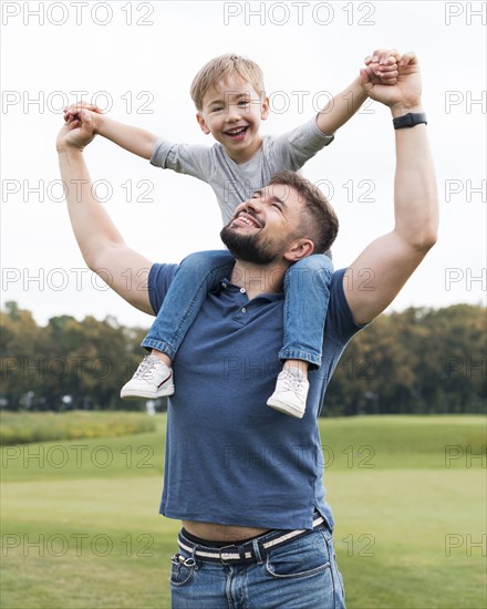 Father holding his son his shoulders front view