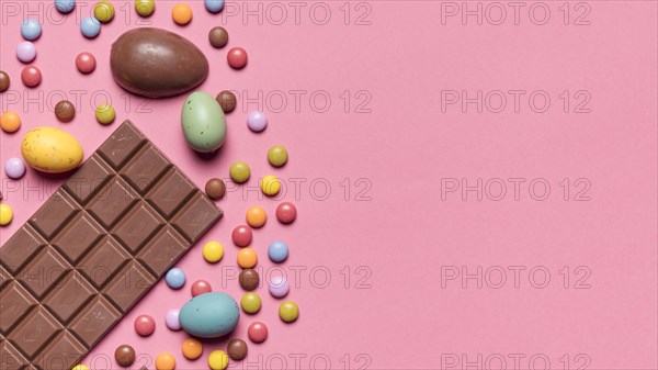 Chocolate bar easter eggs gem candies pink background