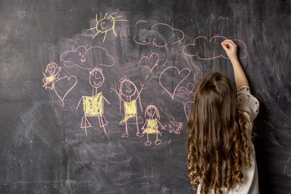 Little girl drawing family blackboard