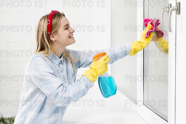 Side view woman cleaning windows