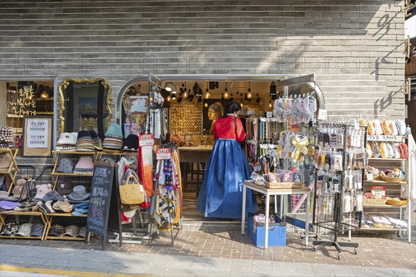 Young woman dressed in traditional Hanbok standing in a souvenir shop near Bukchon Hanok Village