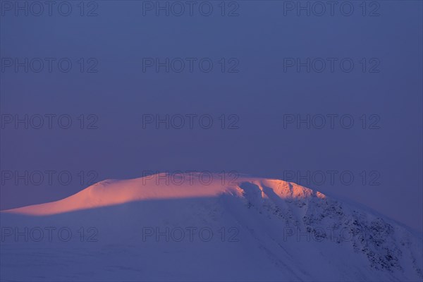 Alpenglow on the Storhoe mountain peak in winter