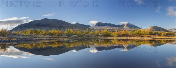 The mountains Hogronden and Digerronden reflected in water of lake in autumn