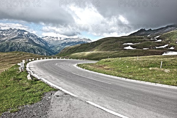 Photo with reduced dynamic range saturation HDR of view of winding road with tight curve road border small boundary posts mountain pass alpine mountain road alpine road pass road old Grossglockner High Alpine Road Grossglockner High Alpine Road above above tree line