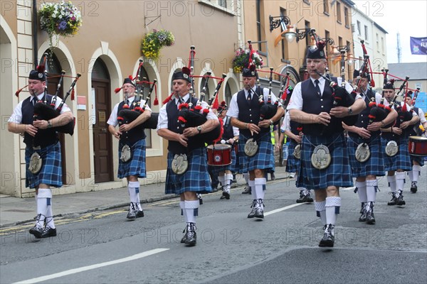 Irish bagpipers in kilts march at the head of the final parade to mark the close of Fleadh Cheoil na hEireann