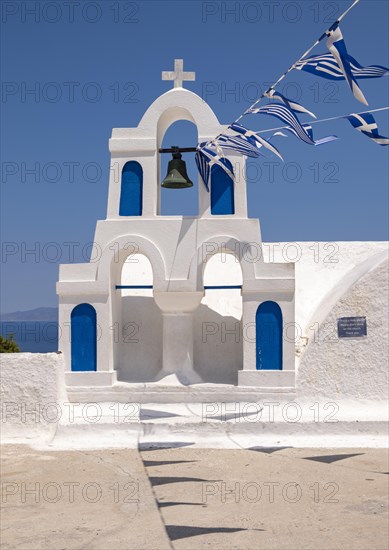 White bell tower with Greek flags