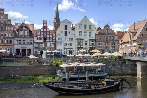 Historic half-timbered houses at the former harbour of the Ilmenau with an old museum ship