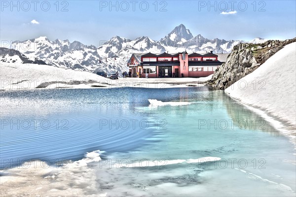 Photo with reduced dynamic range saturation HDR of mountain pass alpine mountain road alpine road pass road pass with snow and ice on mountain lake at pass height of Nufenen pass