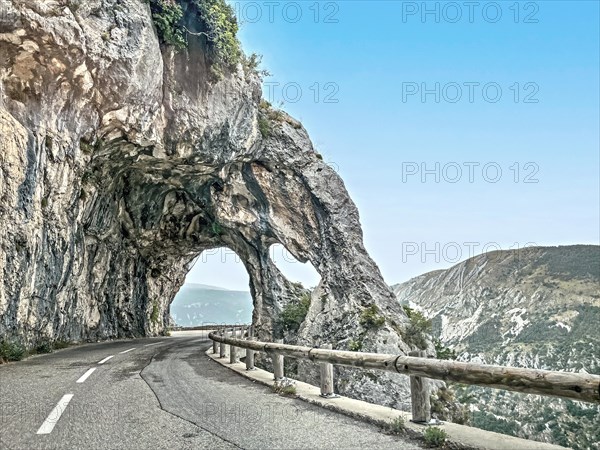 Photo with reduced dynamic range saturation HDR of view of rock arch rock formation with passage on road Route de Gentelly