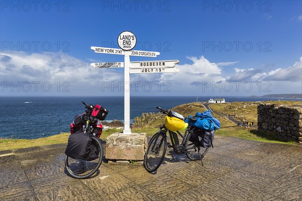 Two e-bikes at the famous signpost to New York