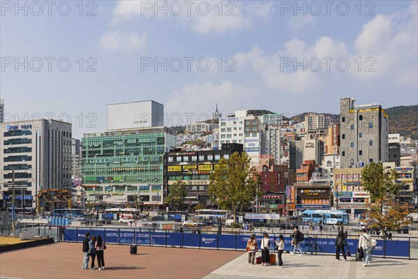 Station forecourt with high-rise buildings and shops