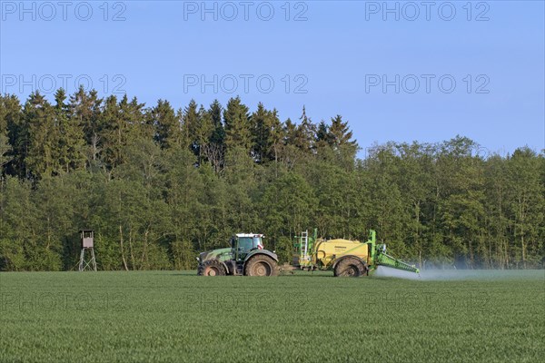 Farmer in tractor spraying herbicides