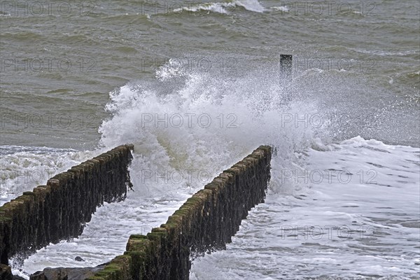 Wave crashing into wooden groyne