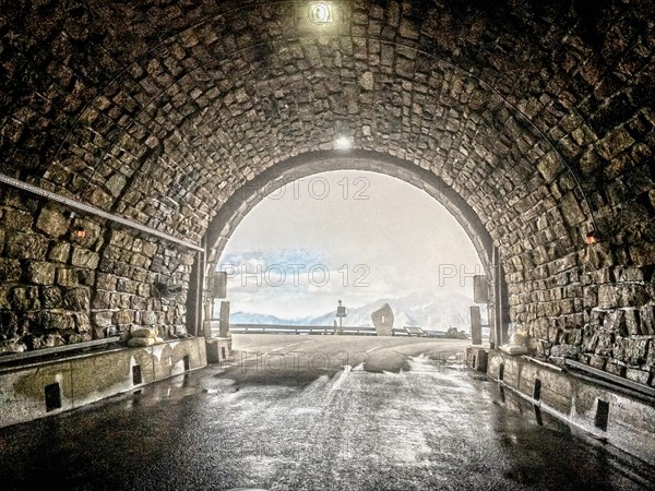 Photo with reduced dynamic saturation HDR of mountain pass alpine mountain road alpine road pass road pass view from tunnel Hochtor of Grossglockner High Alpine Road Grossglockner High Alpine Road in alpine high mountain massif of Grossglockner Massif