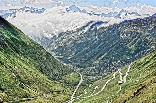 Photo with reduced dynamic saturation HDR of view on in the background Grimselpass front mountain pass alpine mountain road alpine road road pass road pass on Furka Furka pass above above tree line in Swiss Alps High Alps